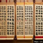 북한의 족보 - A detailed, elegant Korean Joseon Dynasty family genealogy scroll displayed on a wooden table, featu...